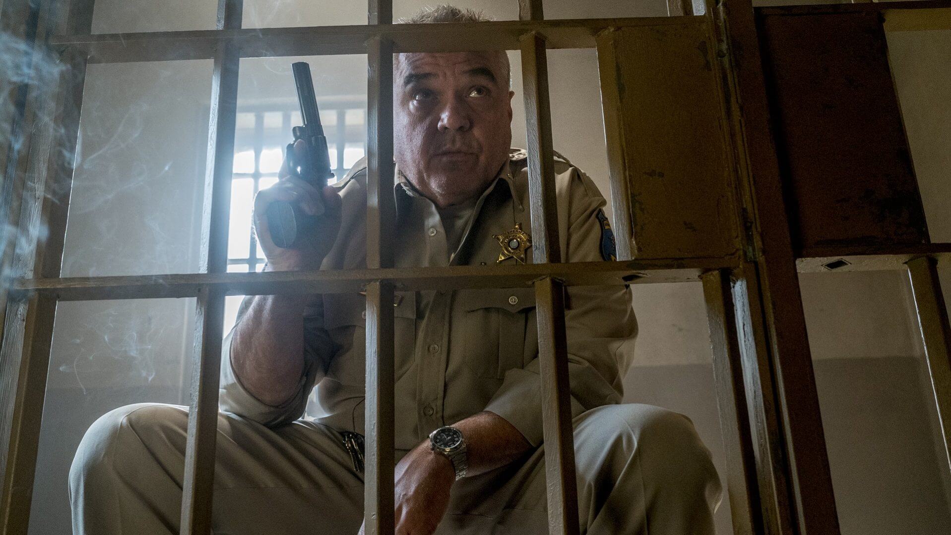 Sheriff Root in Preacher sitting with revolver drawn