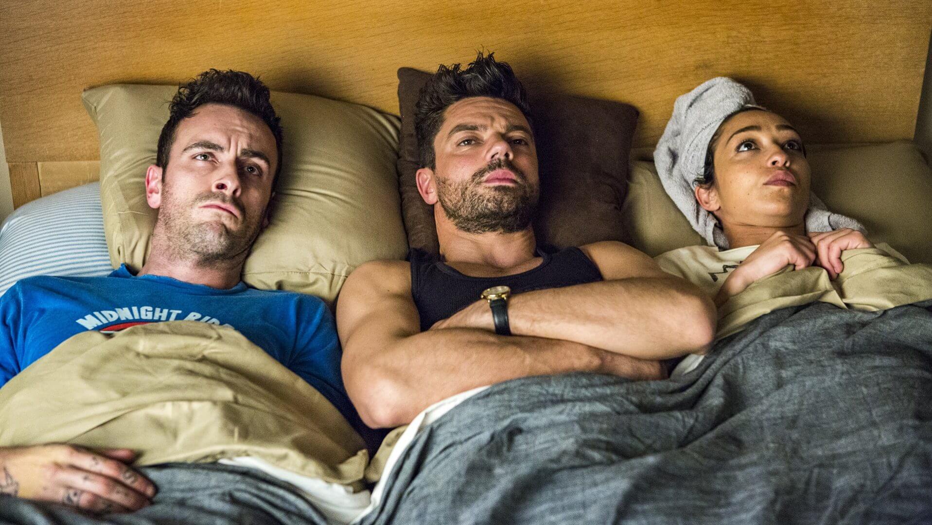 Joe Gilgun as Cassidy, Domic Cooper as Jesse and Ruth Negga and Tulip all laying in bed together in season two of Preacher