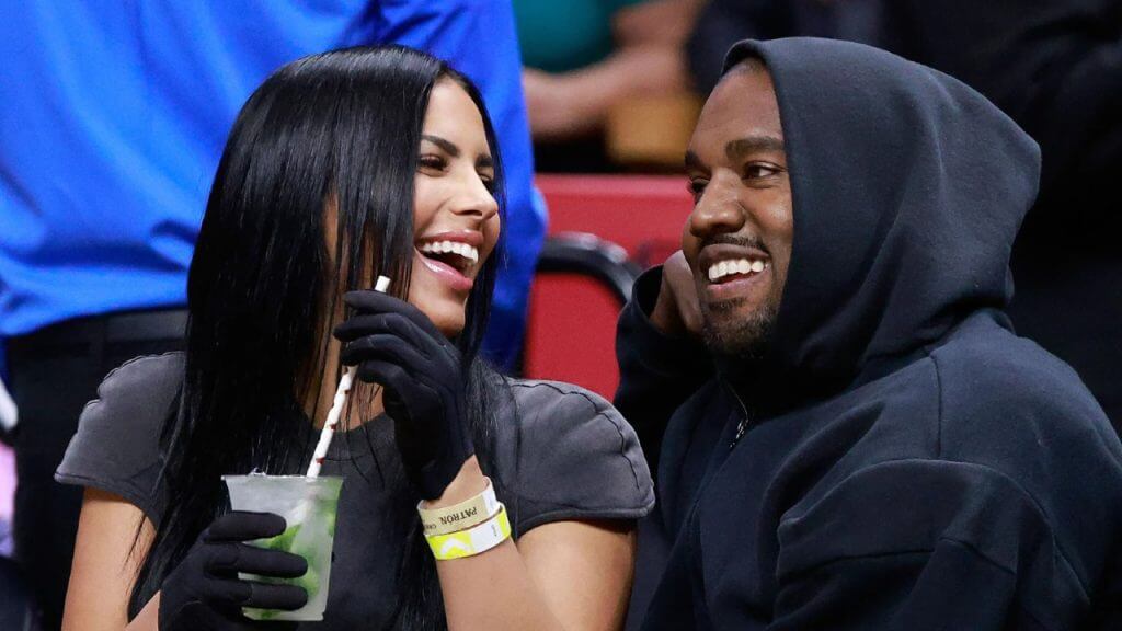 Kanye West and Chaney Jones laugh during NBA Game