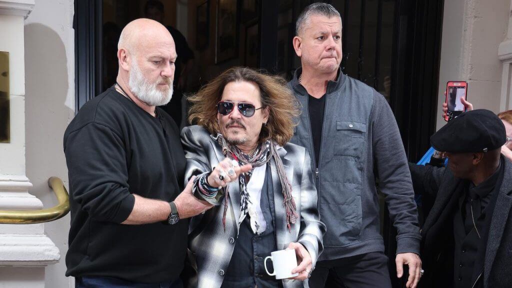 Security men escort Johnny Depp out of hotel