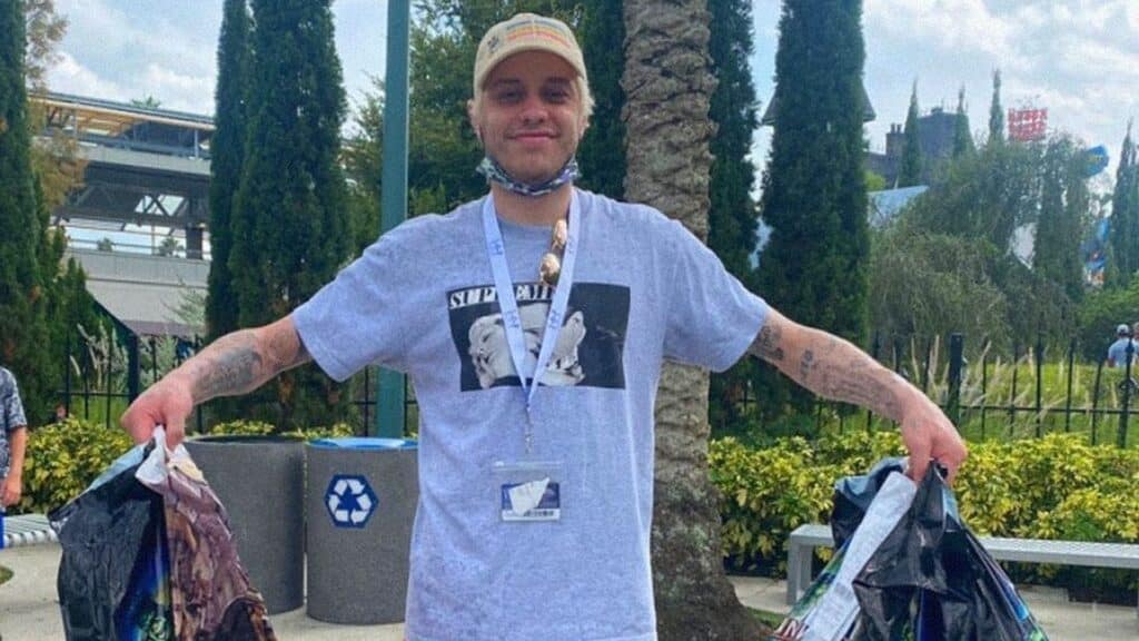 Pete Davidson strikes pose in front of a house