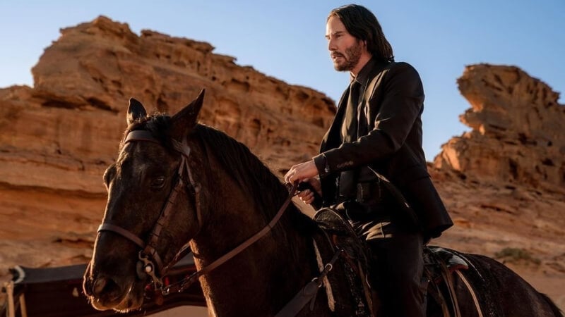 John Wick rides through the desert on a horse