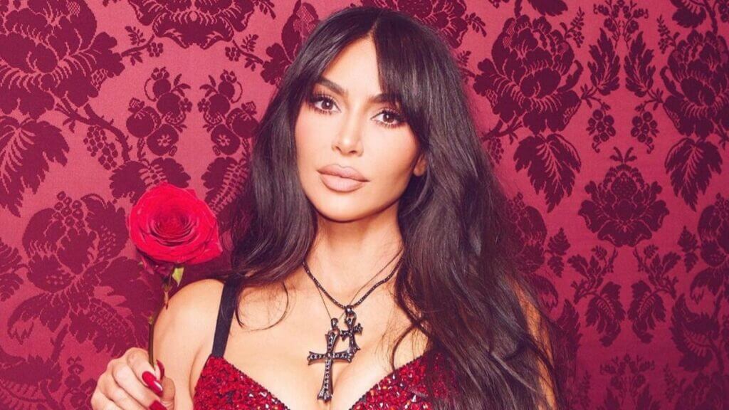 Kim Kardashian poses holding a red rose