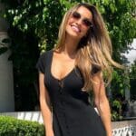 Chrishell Stause poses cheerfully in a black dress