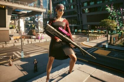 V poses in Night City with her sniper rifle in Cyberpunk 2077