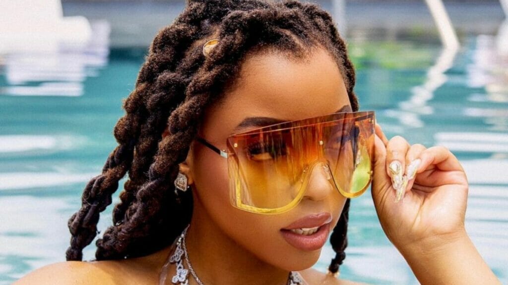 Chloe Bailey rocks eye glasses and bikini in a pool