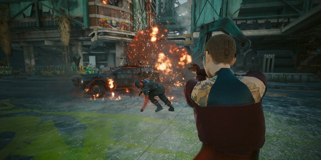 V aims her gun at an exploding car in CD Projekt Red's dystopian RPG