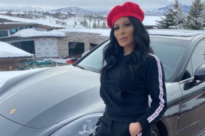 Jen Shah posing in a red beret and designer athleisure