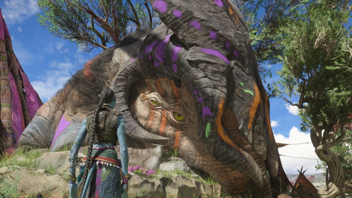 The main character stands in front of a giant creature in Avatar: Frontiers of Pandora