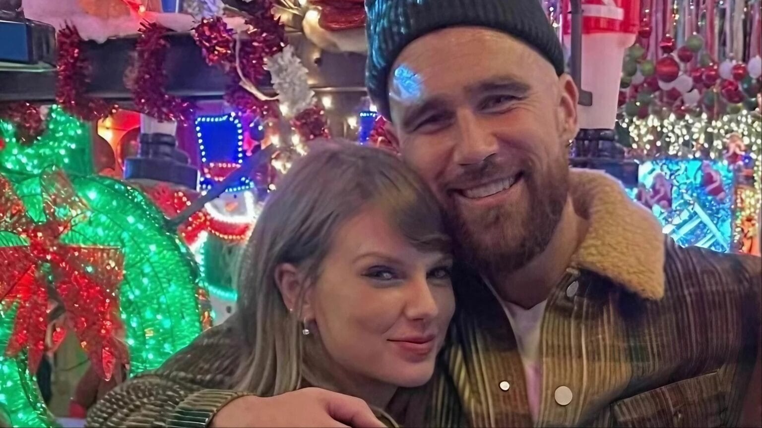 Taylor Swift and Travis Kelce pose for a photo.