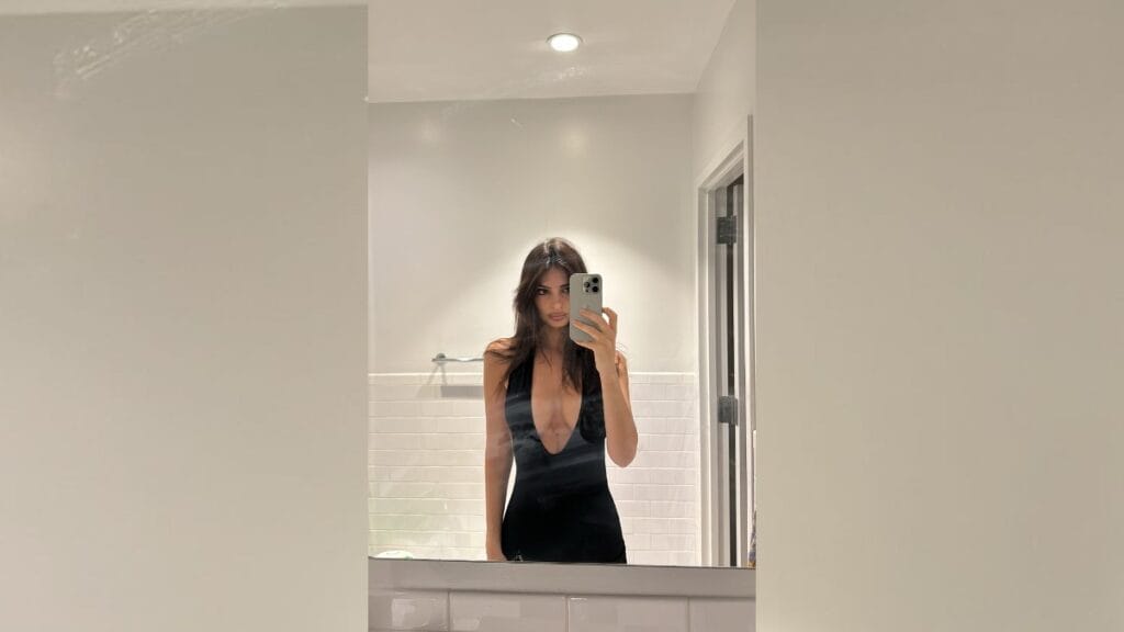 Emily Ratajkowski in a plunging black dress for bathroom mirror selfie