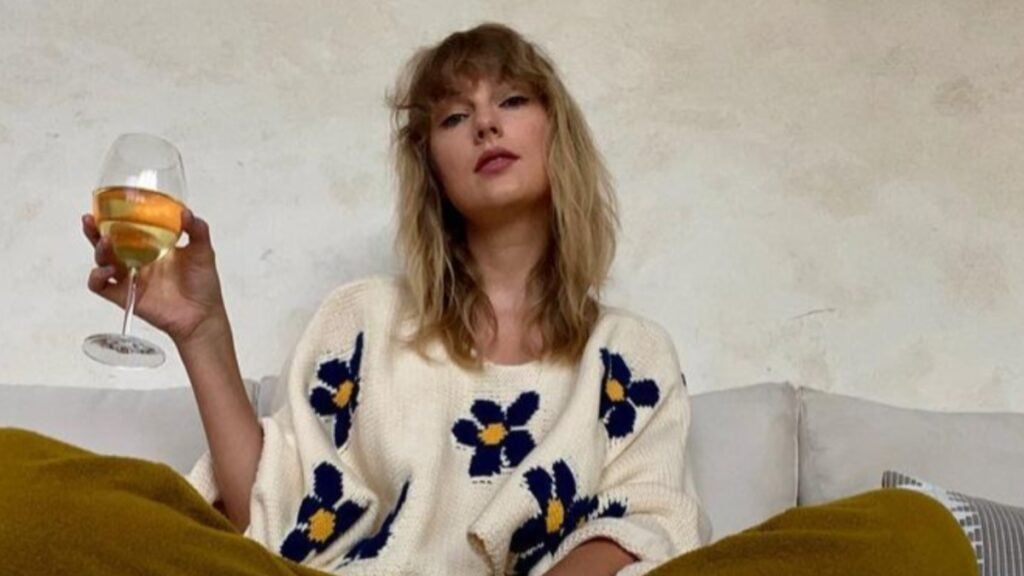 Taylor Swift holding wine.