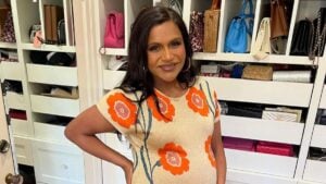 Mindy Kaling in a dress flaunting her baby bump